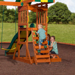 Child climbing the rock wall ladder of the Sunnydale Cedar Swing Set